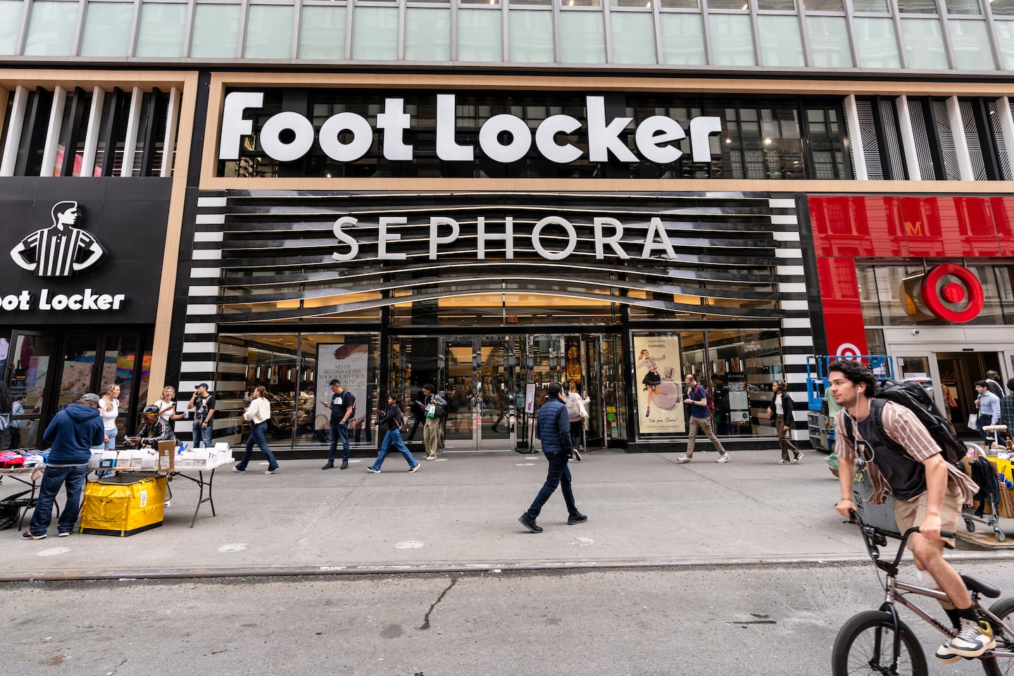 People walk in front of a Foot Locker store on 34th Street.