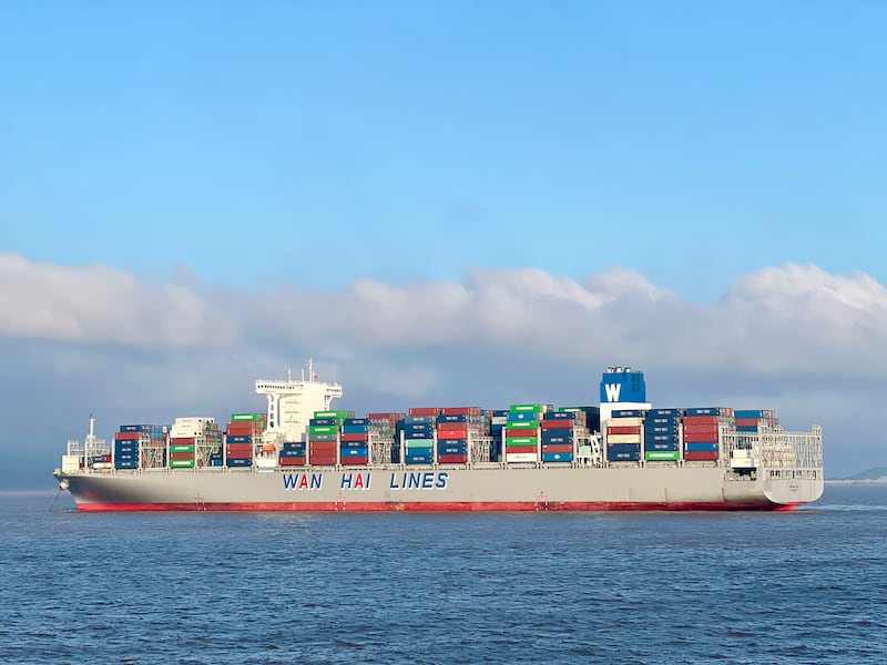 A cargo ship fully loaded with containers sails in the waters of Zhoushan City, Zhejiang Province, China.