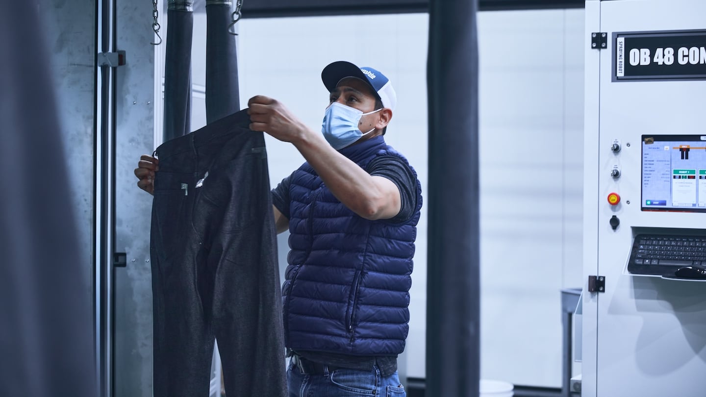 A worker holds up a pair of jeans in Saitex's LA factory.
