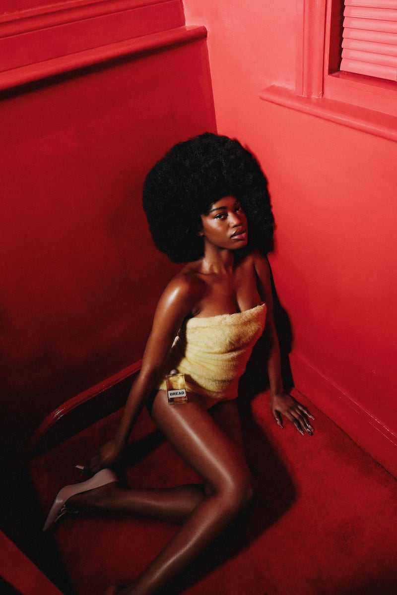 A woman posing with a bottle of hair oil.